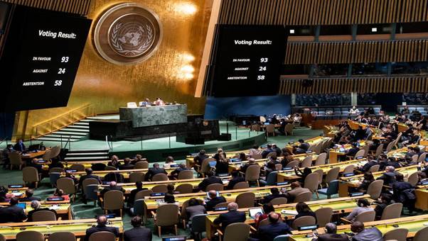 United Nations General Assembly meeting showcasing the voting results displayed on large screens, indicating 93 votes in favour, 24 against, and 58 abstentions.