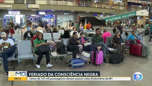 Passengers waiting at a bus terminal with luggage, showing a busy travel day.